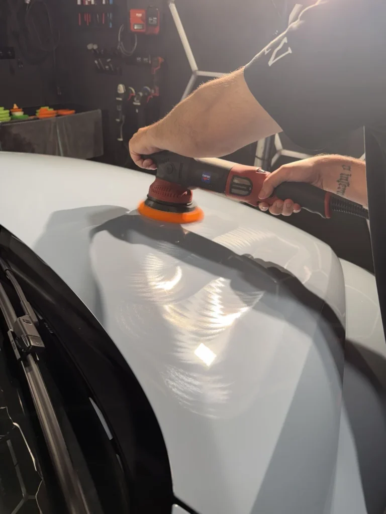 Exercice de correction de peinture sur un capot gris en atelier — formation Belgium Detailing Academy à Manage