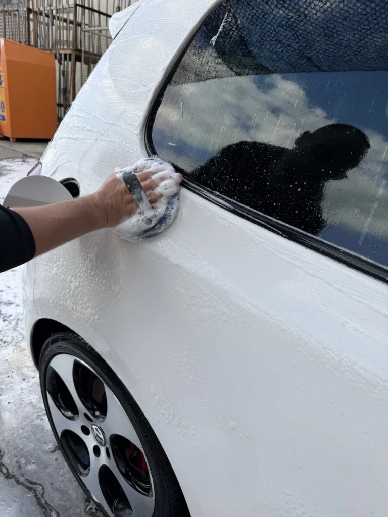 Lavage manuel d’une Volkswagen blanche avec un gant de lavage — formation Belgium Detailing Academy à Manage