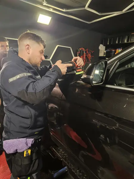 Travail avec mini-polisseuse sur une carrosserie BMW