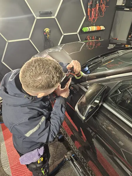 Travail avec mini-polisseuse sur une carrosserie BMW