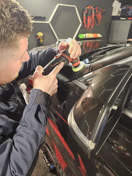 Travail avec mini-polisseuse sur une carrosserie BMW