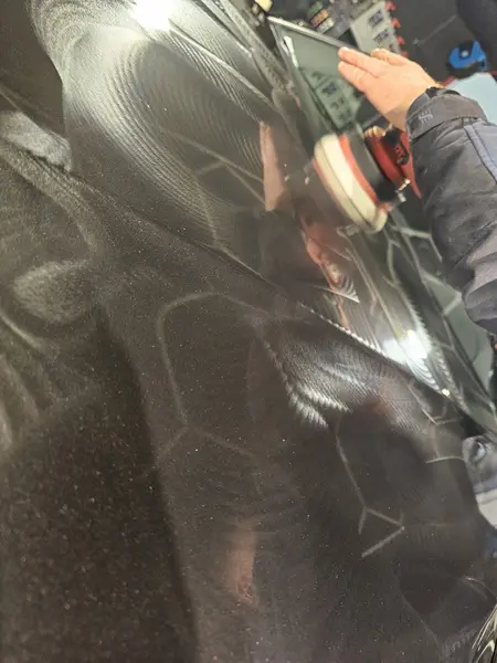 Travail avec mini-polisseuse sur une carrosserie BMW