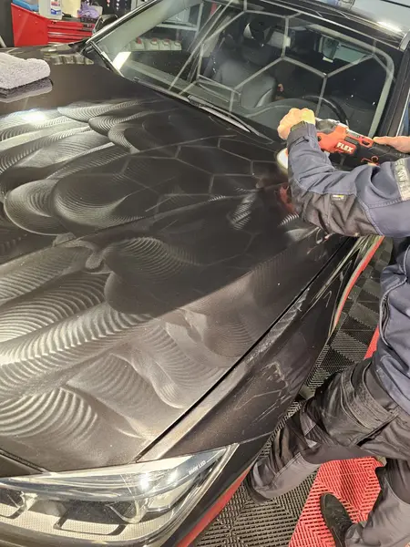 Travail avec mini-polisseuse sur une carrosserie BMW