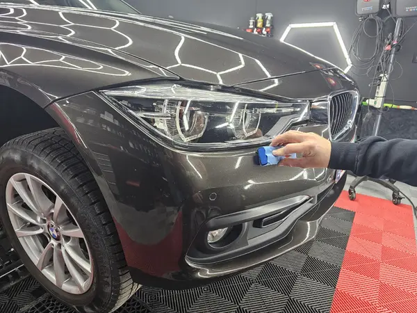 Travail avec mini-polisseuse sur une carrosserie BMW