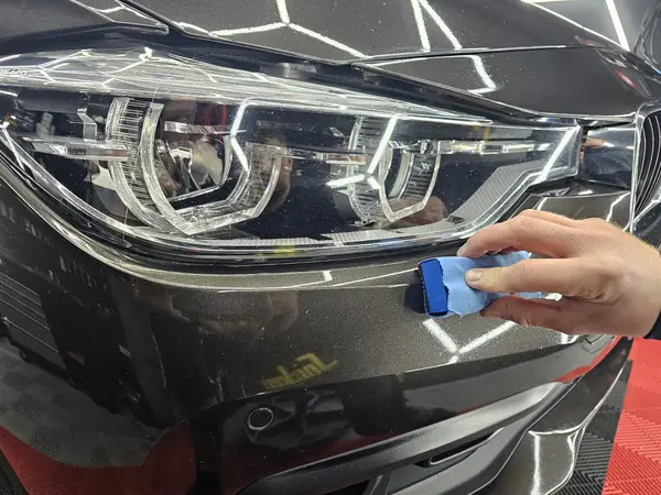 Travail avec mini-polisseuse sur une carrosserie BMW