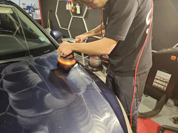 Polissage d’un capot bleu avec une machine orbitale — Belgium Detailing Academy, formation automobile à Manage