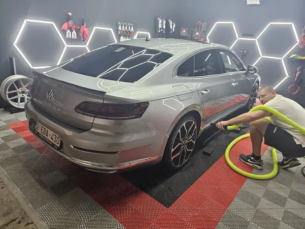 Aspiration près d’une berline grise dans l’atelier — Belgium Detailing Academy, formation automobile à Manage