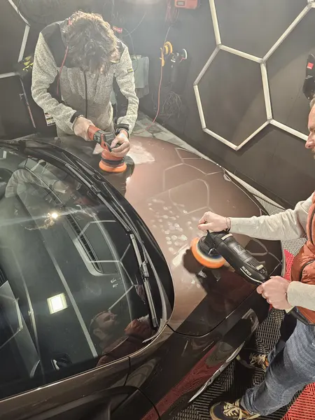 Travail à deux sur un capot brun — Belgium Detailing Academy, formation automobile à Manage