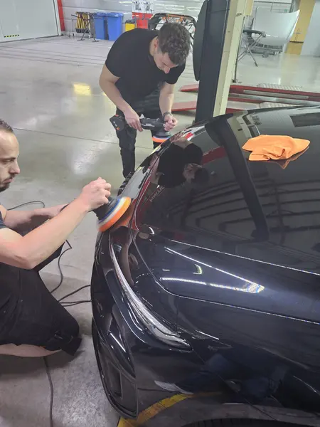Deux participants travaillent sur une carrosserie sombre — Belgium Detailing Academy, formation automobile à Manage
