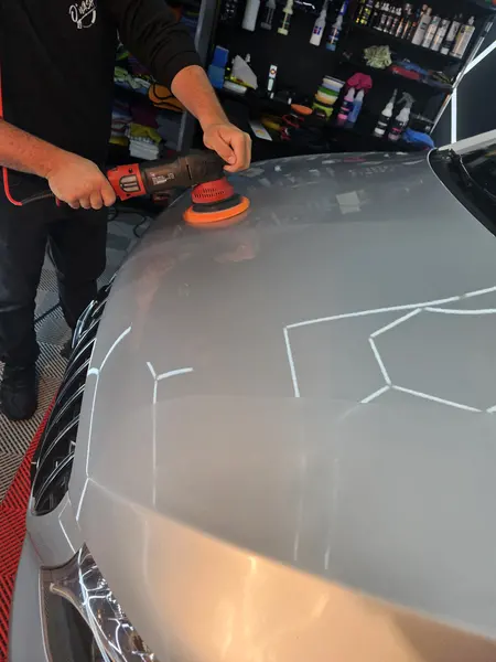Participant au travail sur le capot d’un véhicule clair — Belgium Detailing Academy, formation automobile à Manage