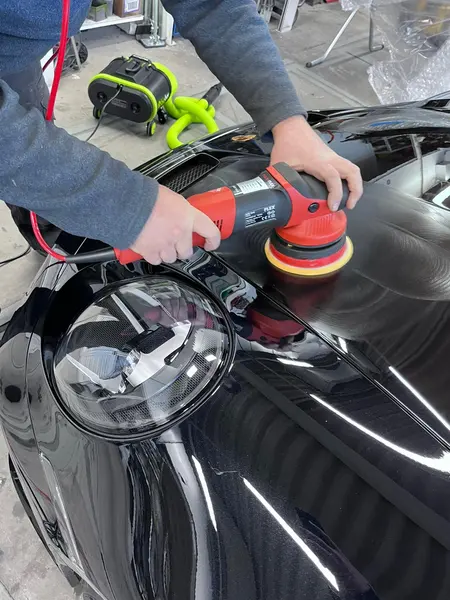 Travail à la polisseuse sur le capot d’une Porsche noire — Belgium Detailing Academy, formation automobile à Manage