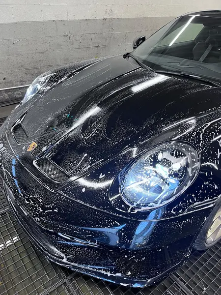 Porsche noire pendant un lavage à la mousse — Belgium Detailing Academy, formation automobile à Manage