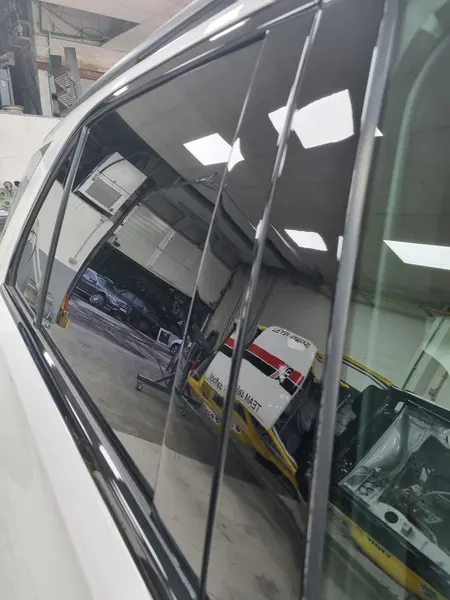 Reflets de la façade dans une vitre automobile — Belgium Detailing Academy, formation automobile à Manage
