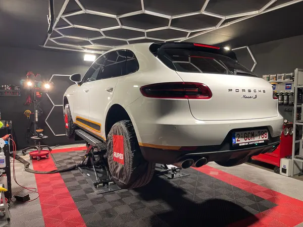 SUV blanc installé sur un pont dans l’atelier — Belgium Detailing Academy, formation automobile à Manage