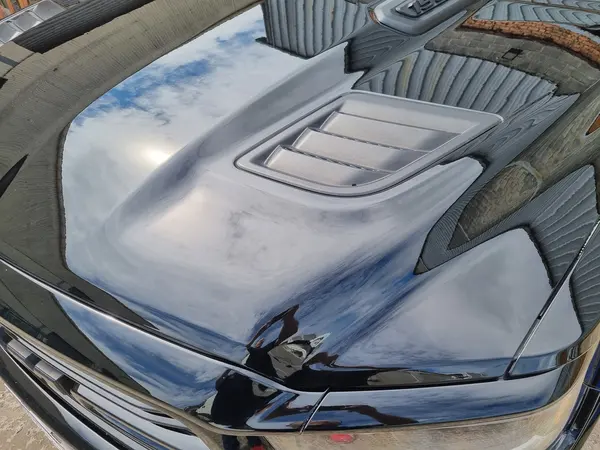 Vue du capot d’une voiture sombre en extérieur — Belgium Detailing Academy, formation automobile à Manage