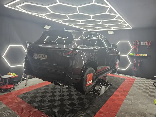 Voiture noire installée sur le pont de l’atelier — Belgium Detailing Academy, formation automobile à Manage