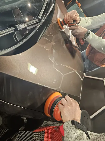 Deux personnes travaillent sur un panneau de carrosserie gris — Belgium Detailing Academy, formation automobile à Manage
