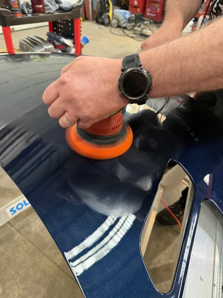 Travail de polissage sur un panneau de carrosserie bleu — formation Belgium Detailing Academy à Manage